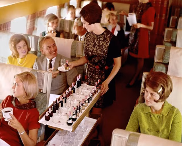 Tiếp viên hãng hàng không Delta phục vụ rượu vang cho hành khách trên một chuyến bay năm 1959. Ảnh: Insider.