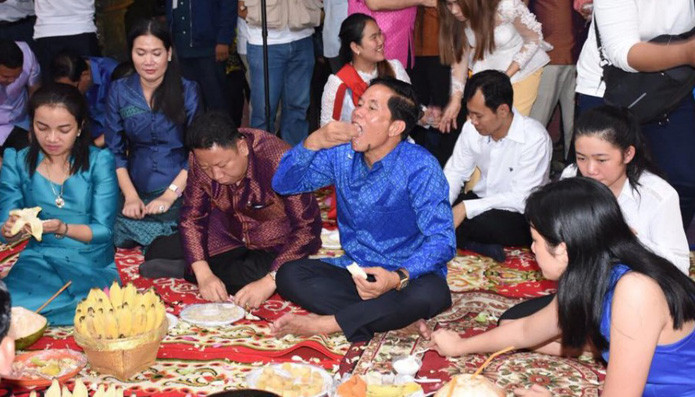 Buổi tối, mọi người đặt đồ cúng vào khay, đem để trên một chiếc chiếu lớn trước, thảnh thơi ngồi chờ trăng lên. Ảnh: Kampuchea Thmey.