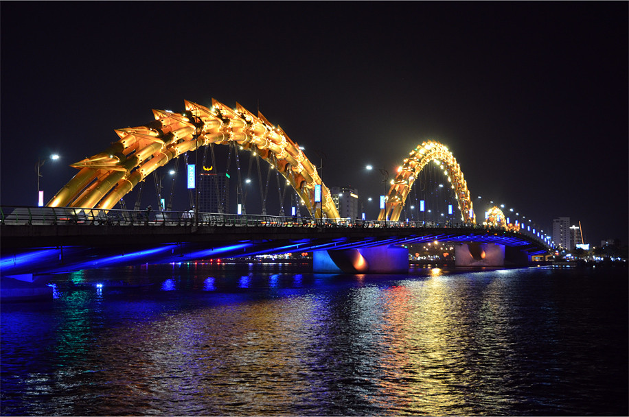 Vào ban đêm, cầu Rồng mang một diện mạo hoàn toàn khác với ánh đèn lung linh huyền ảo. Ảnh: Notesplusultra.com.