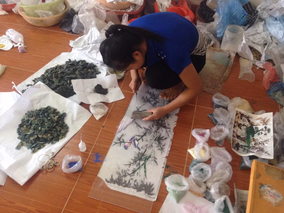 Các mẫu thiết kế tranh đá quý 3D của xưởng anh chủ yếu là về tranh chân dung, tranh tĩnh vật hay những danh lam thắng cảnh nổi tiếng của đất nước. Ảnh : Nghệ nhân đang phác thảo hình dáng ban đầu cho bức tranh đá quý.