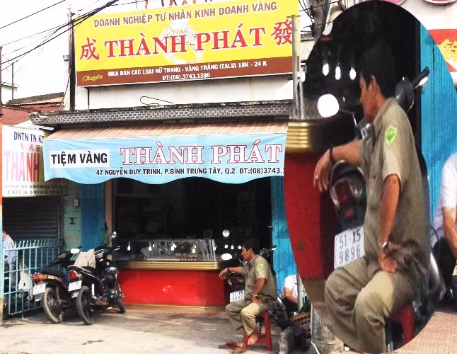 Người đàn ông trong trang phục BVDP ngồi trước tiệm vàng Thành Phát trên đường Nguyễn Duy Trinh, phường Bình Trưng Tây.