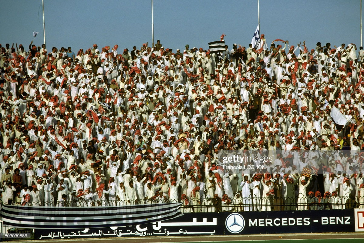 Khán giả trên khán đài của sân vận động đang theo dõi một trận bóng đá.