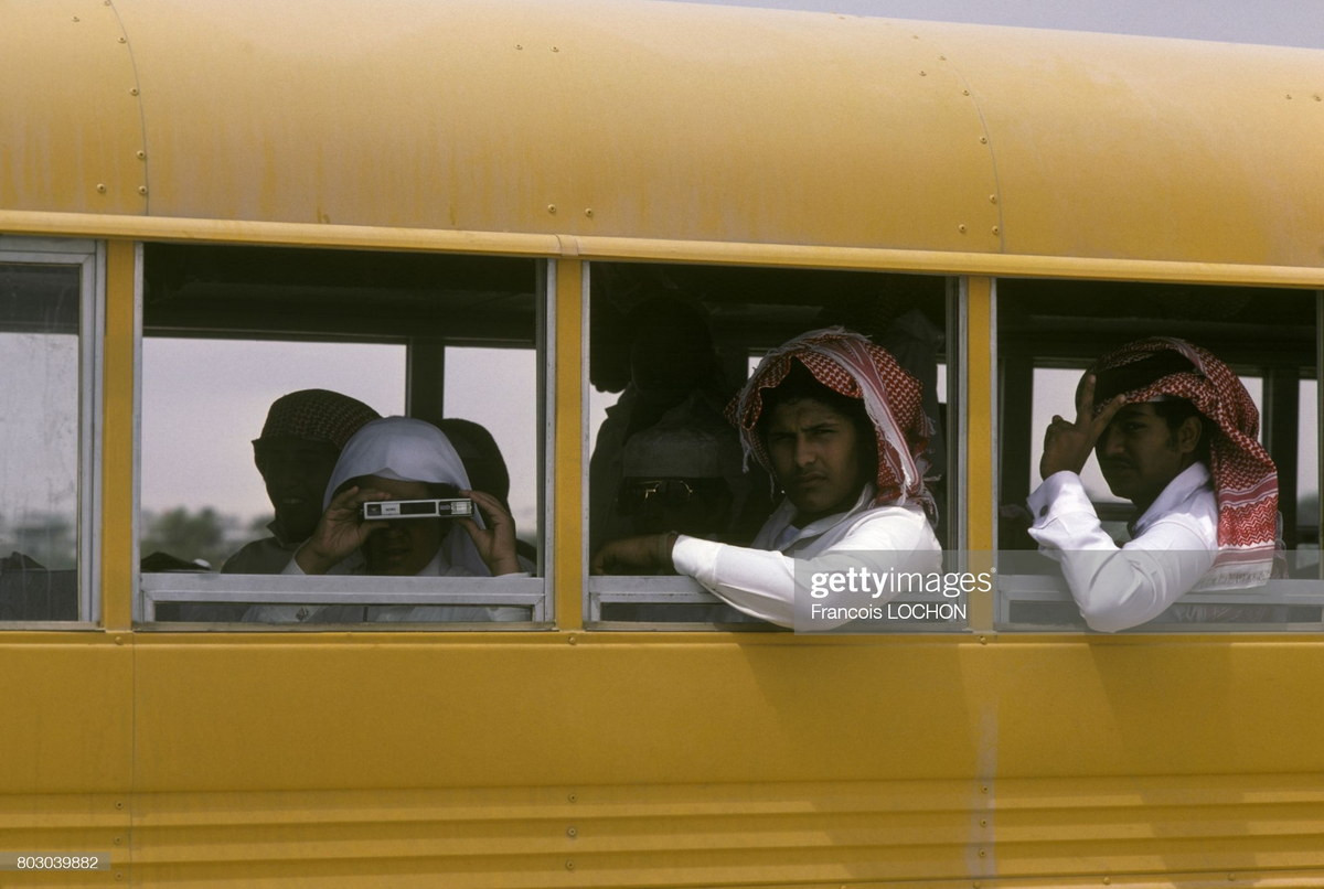 Các hành khách bên ô cửa của một chiếc xe buýt.