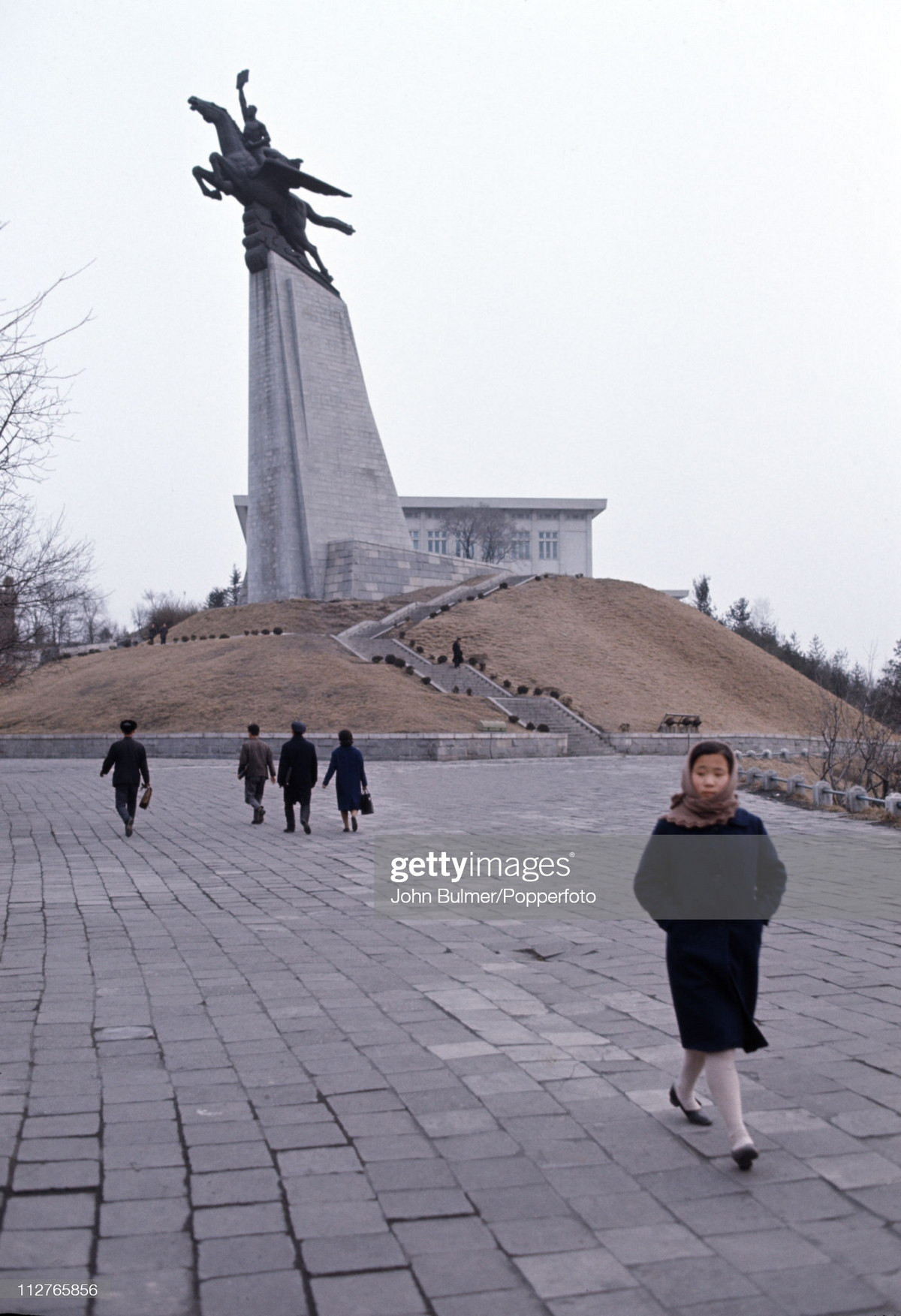 Một người phụ nữ rảo bước ở khu vực tượng đài Thiên Lý Mã.