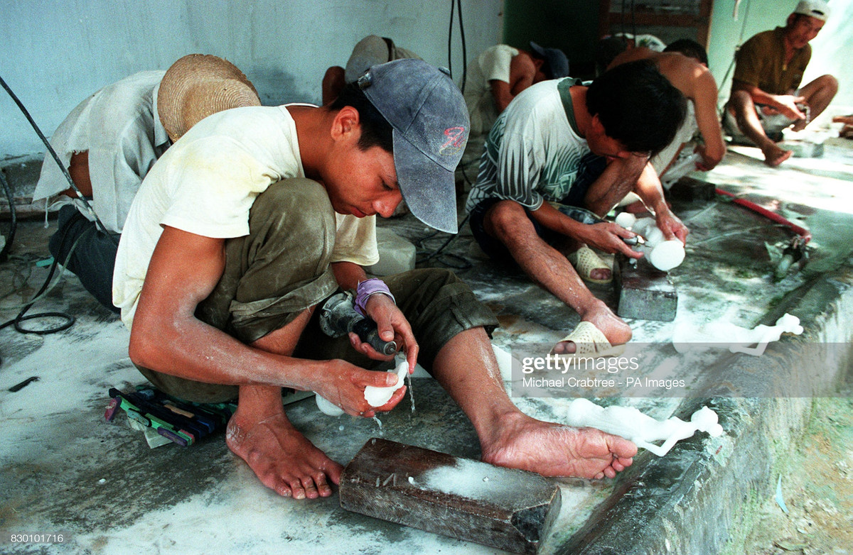 Những người thợ đánh bóng tượng đá tại một xưởng làm tượng ở Huế.