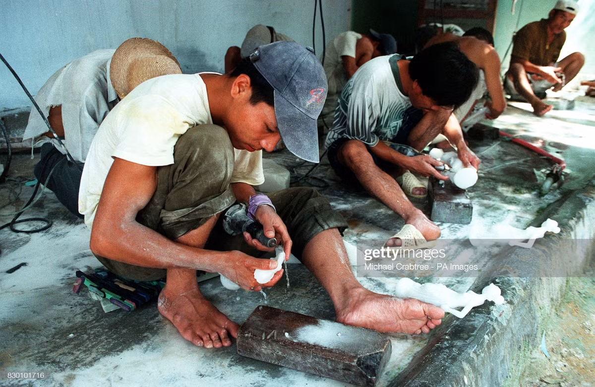 Những người thợ đánh bóng tượng đá tại một xưởng làm tượng ở Huế.