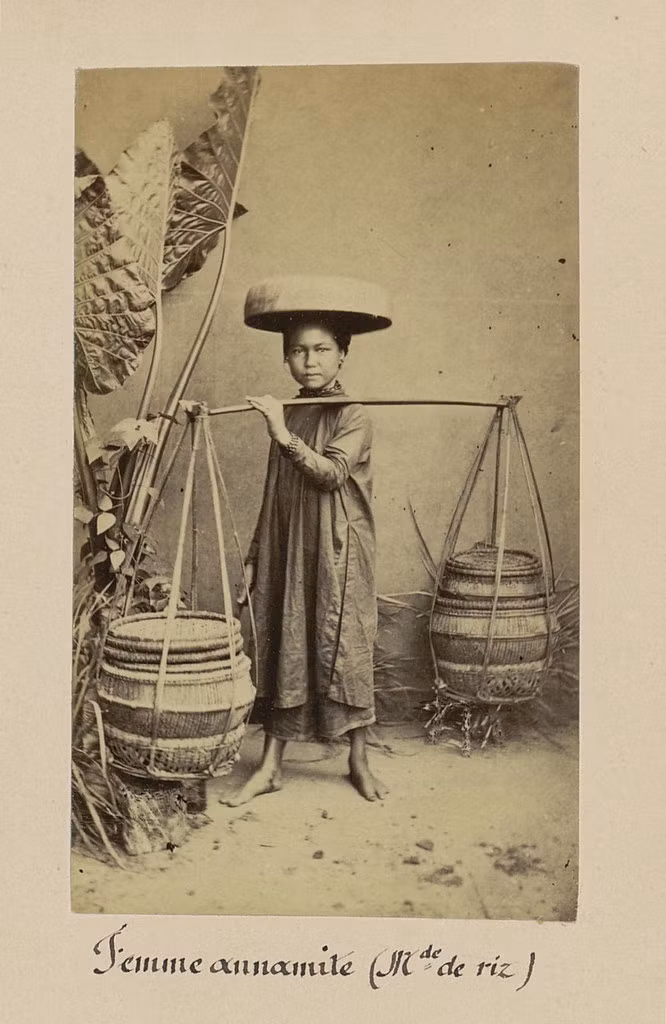 Thiếu nữ nhỏ bé và đôi quang gánh trĩu nặng.