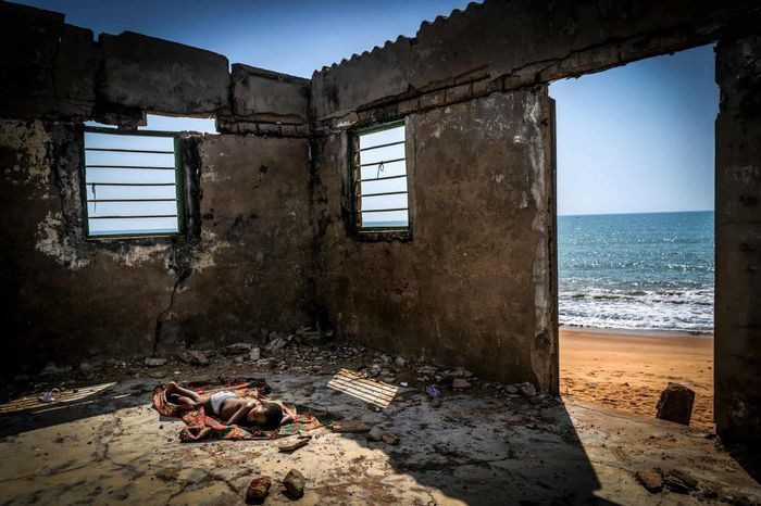 Giải thưởng "Nhiếp ảnh môi trường 2021" thuộc về bức ảnh "The Rising Tide Sons" của nhiếp ảnh gia người Tây Ban Nha Antonio Aragon Renuncio. Bức ảnh được chụp tại Togo, với một bé trai ngủ trên sàn căn nhà đã đổ nát trước sự xói mòn mà biển cả gây ra. Nước biển dâng là một vấn nạn đang đe dọa cuộc sống của người dân Togo cũng như các quốc gia Tây Phi, khiến hàng triệu người mất kế sinh nhai, nhà cửa bị phá hủy. Ảnh: Antonio Aragon Renuncio.