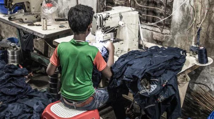 Một cậu bé làm việc trong xưởng may. Không ai biết chắc rằng quần áo chúng ta đang mặc được làm ra từ biết bao giọt mồ hôi của những đứa trẻ bị bóc lột.