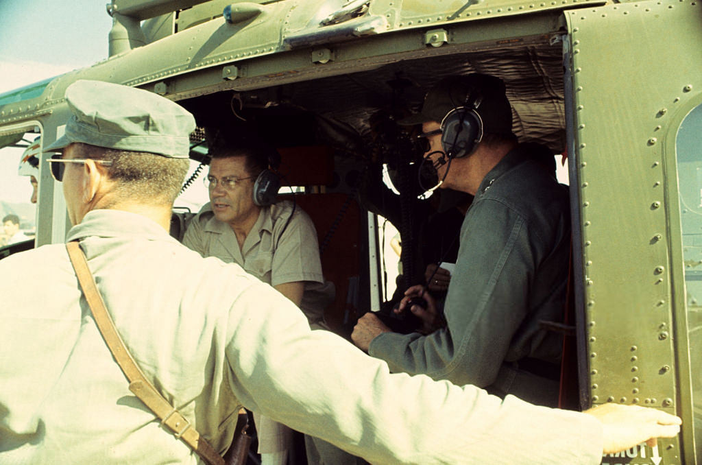 Bộ trưởng Quốc phòng Mỹ Robert McNamara (giữa) ngồi trên một chiếc trực thăng, nói chuyện với hai sĩ quan trong một chuyển khảo sát thực địa tại chiến trường Việt Nam. Ảnh: Jean-Claude Sauer.