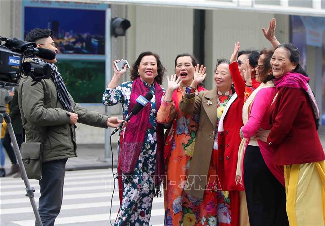 Những phụ nữ trung niên trong trang phục áo dài truyền thống chia sẻ cảm xúc ngày đầu năm mới. #