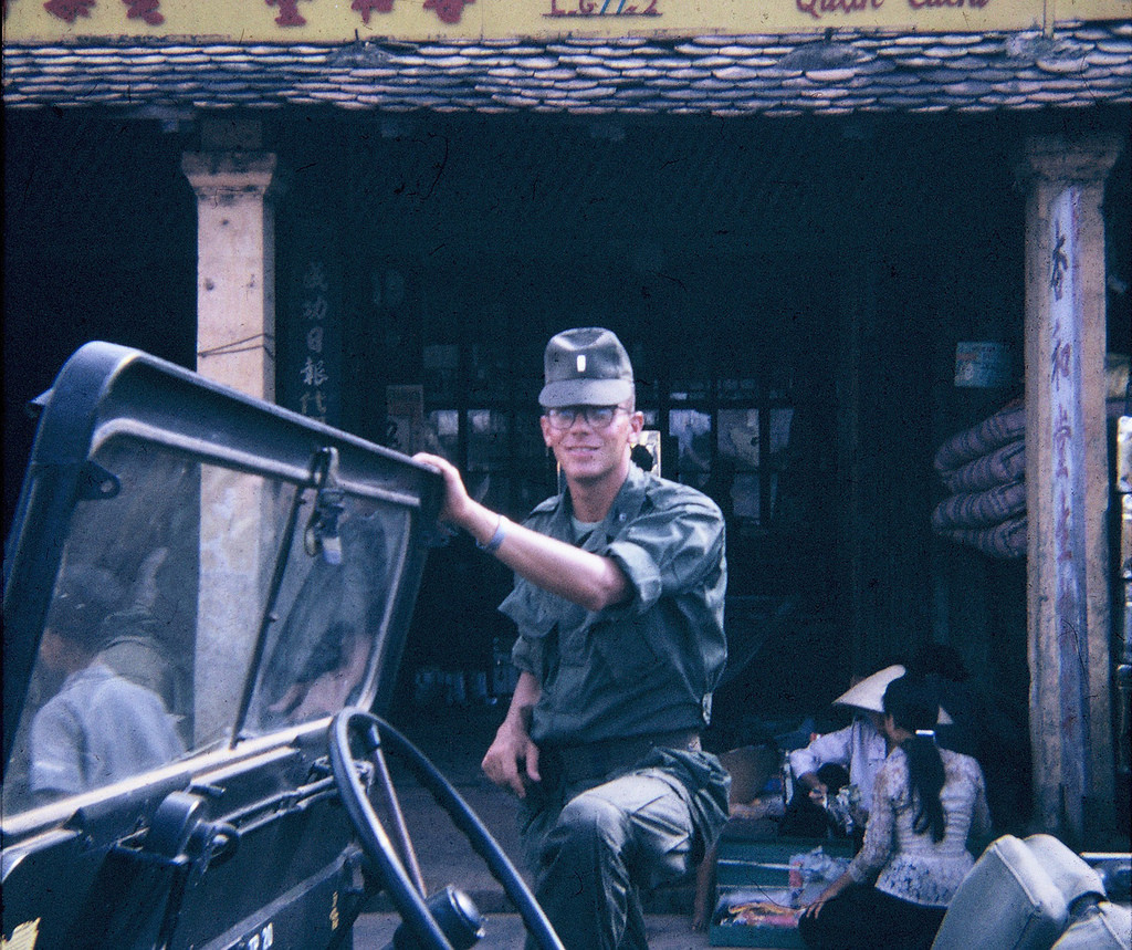 Lính Mỹ chụp ảnh lưu niệm trước tiệm tạp hóa ở Củ Chi. Ảnh: Allen Hinnman.