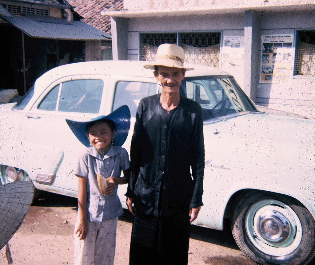 Hai ông cháu tạo dáng trước ống kính máy ảnh trên đường phố Củ Chi. Ảnh: Allen Hinnman.