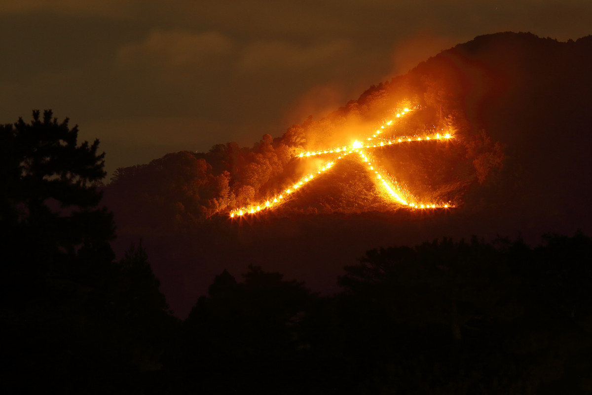 Những đám lửa lớn được sắp xếp theo hình dạng của các chữ Hán. Bắt đầu là chữ Đại (Daimonji), rồi đến Diệu (Myo), Pháp (Ho) và Thuyền (Funagata), chữ Đại nhỏ ở đỉnh núi nhỏ hơn gọi là Hidari-Daimonji, gần với chùa Vàng. Ảnh: Distric81.