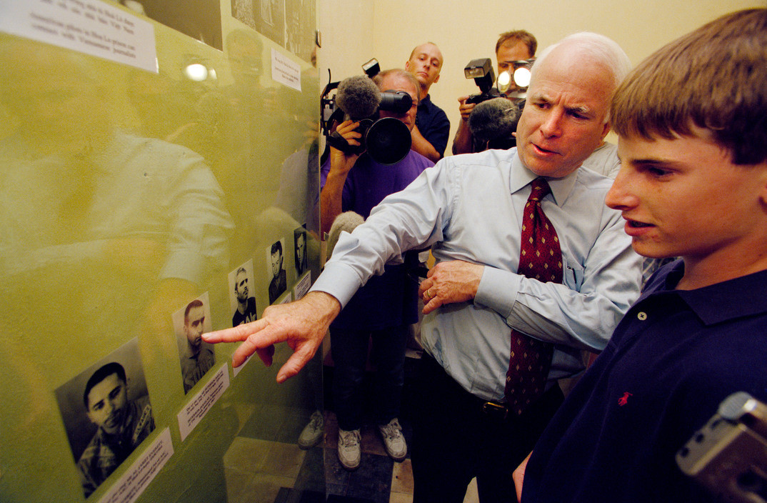 Cựu phi công Mỹ xem ảnh của các đồng đội cũ từng bị giam giữ tại Nhà tù Hỏa Lò. Ảnh: Philip Jones Griffiths/ Magnum.