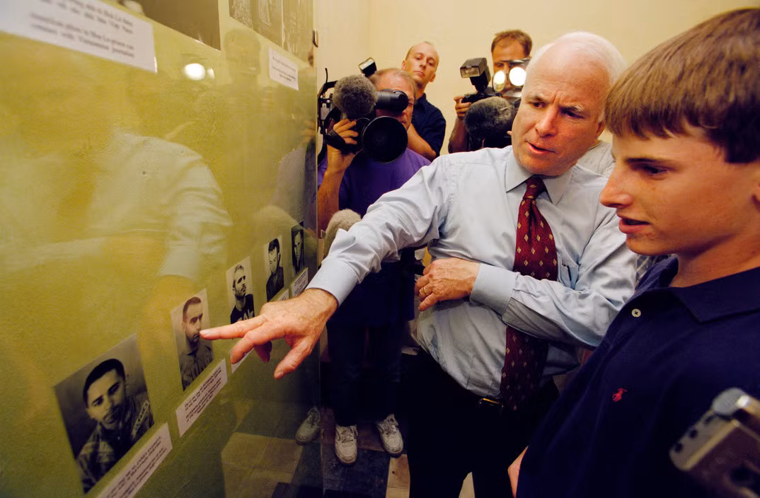 Cựu phi công Mỹ xem ảnh của các đồng đội cũ từng bị giam giữ tại Nhà tù Hỏa Lò. Ảnh: Philip Jones Griffiths/ Magnum.