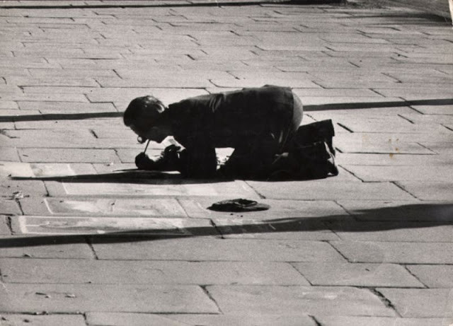 Một nghệ sĩ đường phố vẽ tranh trên những ô gạch vỉa hè. Ảnh: Ernst Haas.