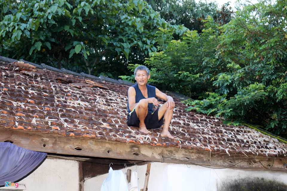 Những hộ dân có nhà bị ngập sâu phải mở đường thoát trên mái ngói. Trong ảnh là ông Nguyễn Văn Sơn (70 tuổi), ở thị trấn Đô Lương, huyện Đô Lương phải trèo lên mái ngói để tránh lũ. Đến ngày 21/8, nước lũ đã rút nhưng vẫn còn rất cao.