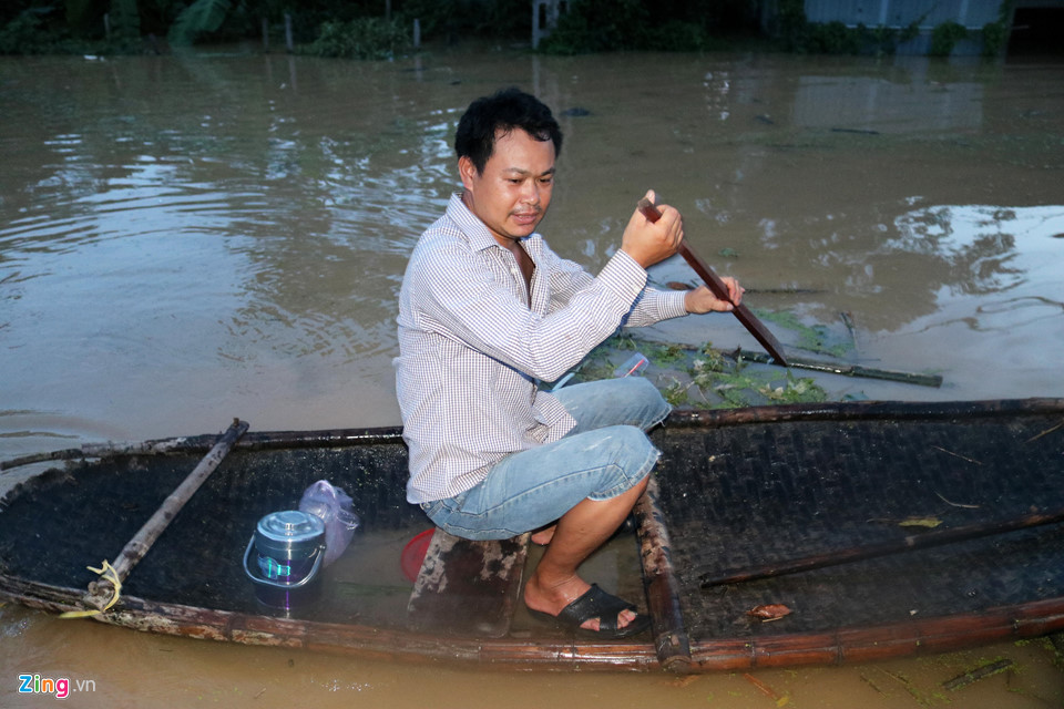 Người dân chèo thuyền nan di chuyển trong nước lũ. Đây là phương tiện duy nhất để di chuyển đến nơi không bị ngập.