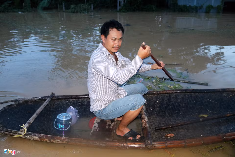 Người dân chèo thuyền nan di chuyển trong nước lũ. Đây là phương tiện duy nhất để di chuyển đến nơi không bị ngập.