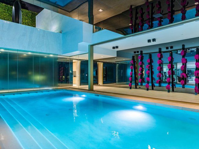 Ngôi nhà có hai bể bơi và một số thiết kế nghệ thuật và điêu khắc bên ngoài.