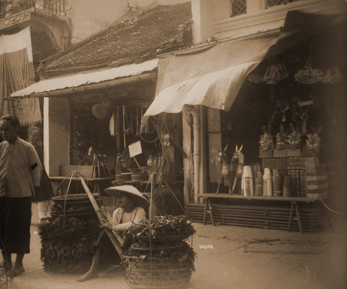 Gánh hàng rau phía trước một cửa hàng bán đồ vàng mã. Vào dịp Trung thu, nhiều gia đình sắm sửa thêm đồ vàng mã để đốt cho người đã mất, bày tỏ lòng thành.