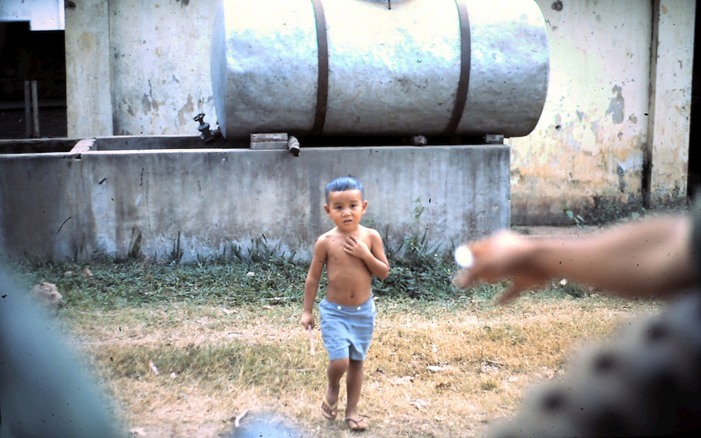 Một em bé ở Phan Thiết lọt vào ống kính lính Mỹ từ chiếc xe quân sự đang di chuyển trên đường.