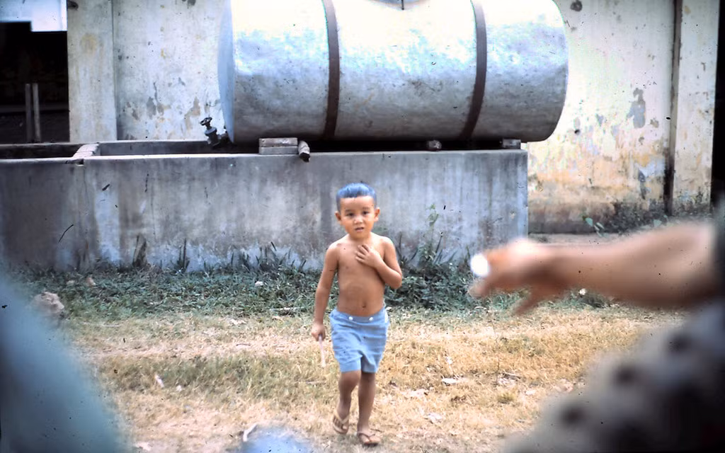 Một em bé ở Phan Thiết lọt vào ống kính lính Mỹ từ chiếc xe quân sự đang di chuyển trên đường.