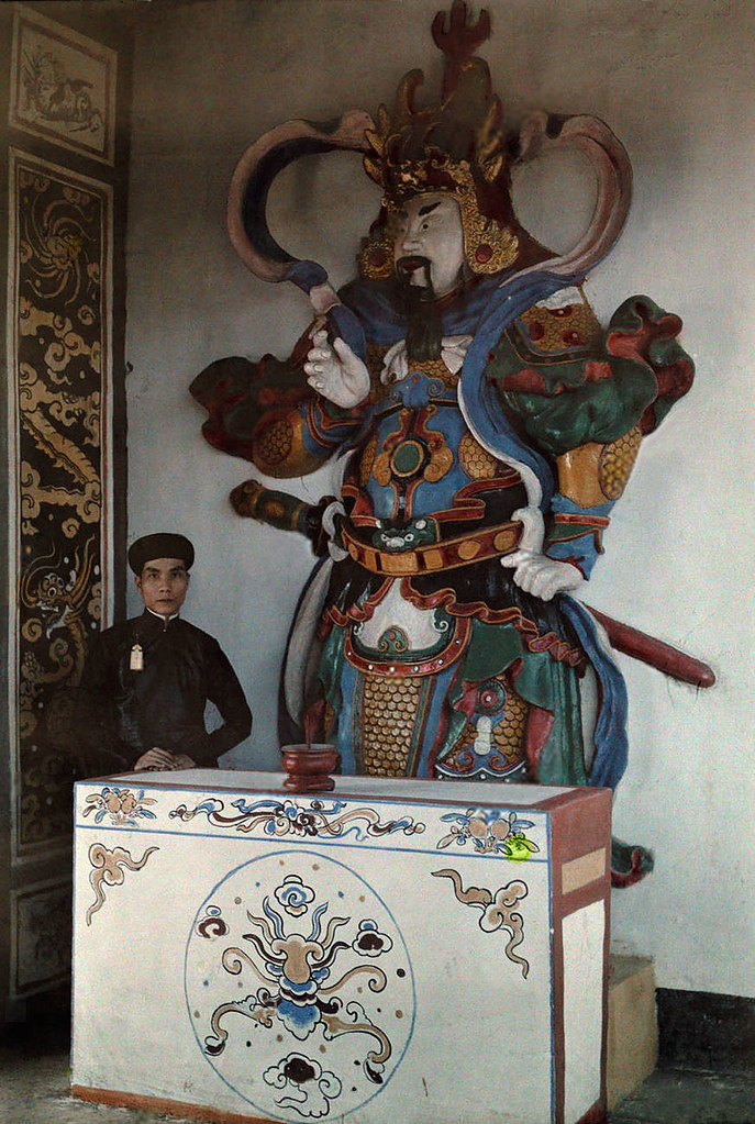 Viên quan trẻ của triều đình Huế đứng bên tượng hộ pháp ở chùa Thiên Mụ, 1931. Ảnh: W. Robert Moore.