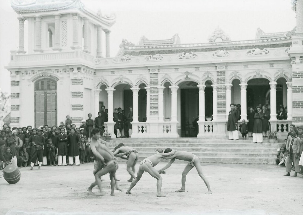 Các đô vật thi đấu trước khu nhà lớn của làng Bình Cách.