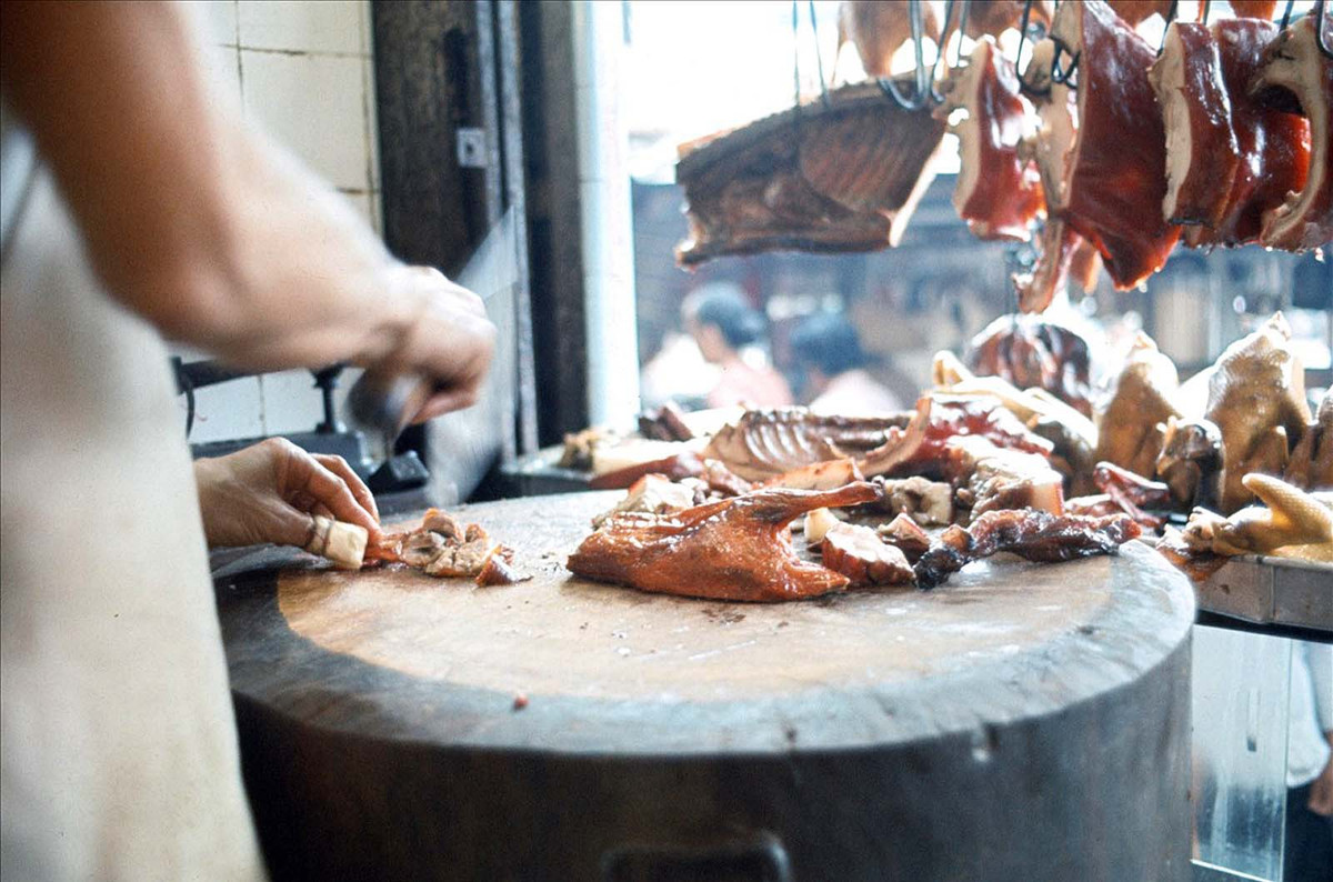 Người bán hàng thái một con vịt quay.