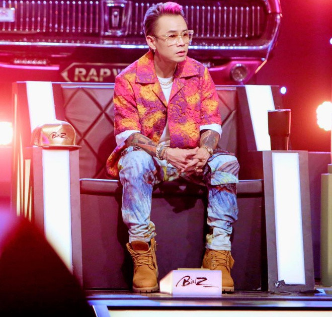 Vẫn ưa chuộng trang phục màu sắc, Binz nhận được nhiều lời khen với set đồ kết hợp sơ mi tie dye cùng quần họa tiết của Daily Paper x Van Gogh có giá 1.041 USD. Trao đổi với Zing về ý tưởng phối đồ cho nam rapper, stylist BaoPaul cho biết: "Trang phục tôi sử dụng cho Binz hướng đến sự hài hòa. Thiết kế đi theo phong cách 'hip-hop old school vibe'. Bên cạnh đó, tôi vẫn sử dụng một vài món đồ tông hồng để thể hiện sắc màu đặc trưng của giọng ca BigCityBoi". Ảnh: Rap Việt.