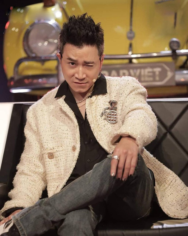 Karik cũng gây chú ý với vẻ ngoài lãng tử xen lẫn cá tính khi diện áo khoác vải tweed. Thiết kế tông kem được phối cùng quần jeans, sơ mi, kính râm và sneakers. Điểm nhấn của bộ đồ nằm ở cách đi giày lệch màu cùng cài áo Chanel. Stylist Hoàng Ku nhận định: "Tôi giúp Karik thể hiện rõ phong cách và cá tính qua trang phục. Để hợp xu hướng hiện đại, một rapper không nhất thiết phải mặc style hip hop". Ảnh: Rap Việt.