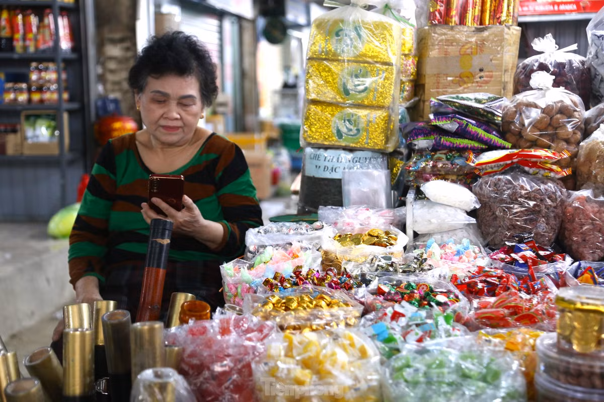 Vắng khách, nhiều tiểu thương ngồi lướt điện thoại giết thời gian.