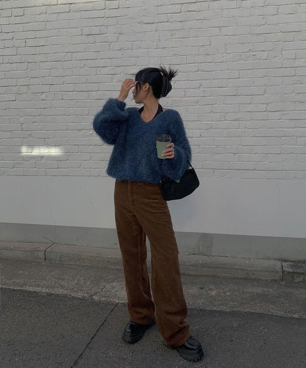 Áo len lông xù cổ tim được diện bên trong chiếc áo cổ yếm màu đen nhìn cá tính hẳn. Mix thêm đôi giày đế "khủng", chiều cao của cô nàng đã ăn gian vài centimet.