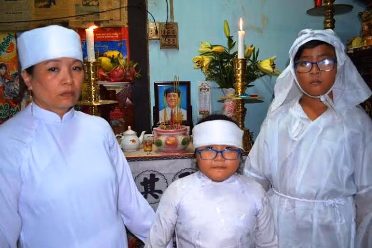 Vợ và 2 con nhỏ của anh Long trước di ảnh chồng, cha.