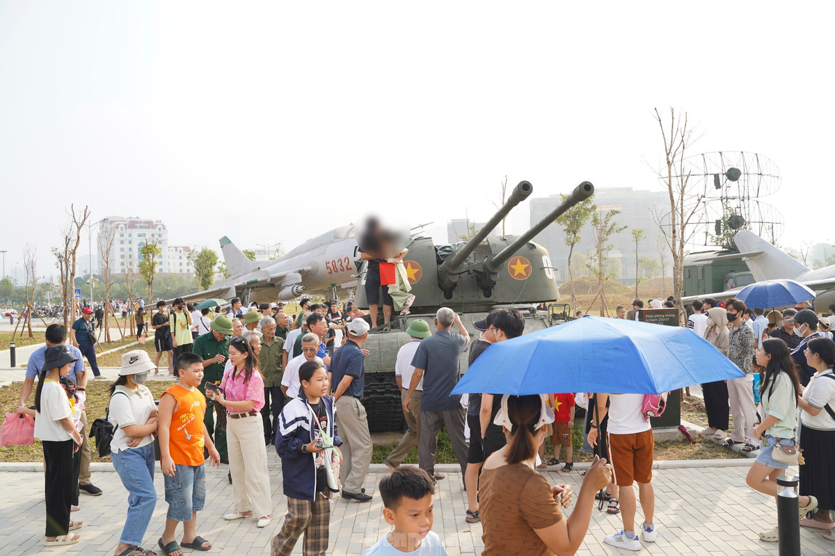 Một phụ huynh bế con leo lên xe tăng đã ngay lập tức bị khách tham quan nhắc nhở.