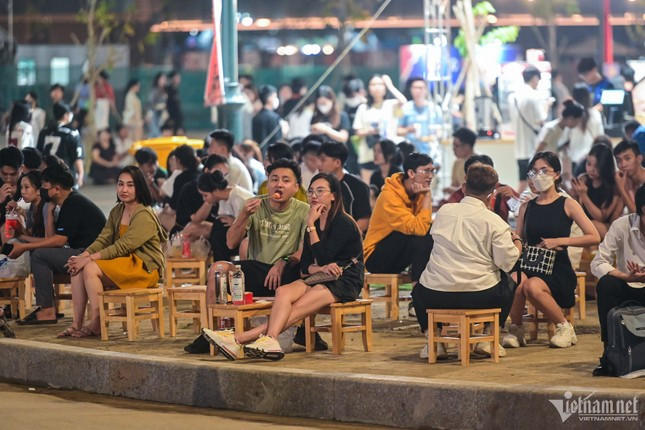 Trong không khí mát mẻ, rất đông bạn trẻ ngồi trước một quán cà phê tại công viên cùng chuyện trò.