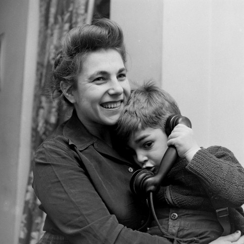 Cậu bé nép mình vào người mẹ và bẽn lẽn gọi điện cho ông già Noel.