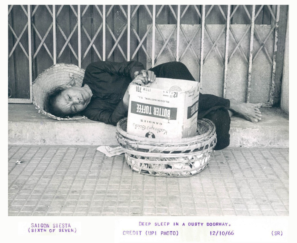 Người bán hàng rong ngủ trên vỉa hè, tay vẫn đặt trên giỏ hàng, Sài Gòn năm 1966.