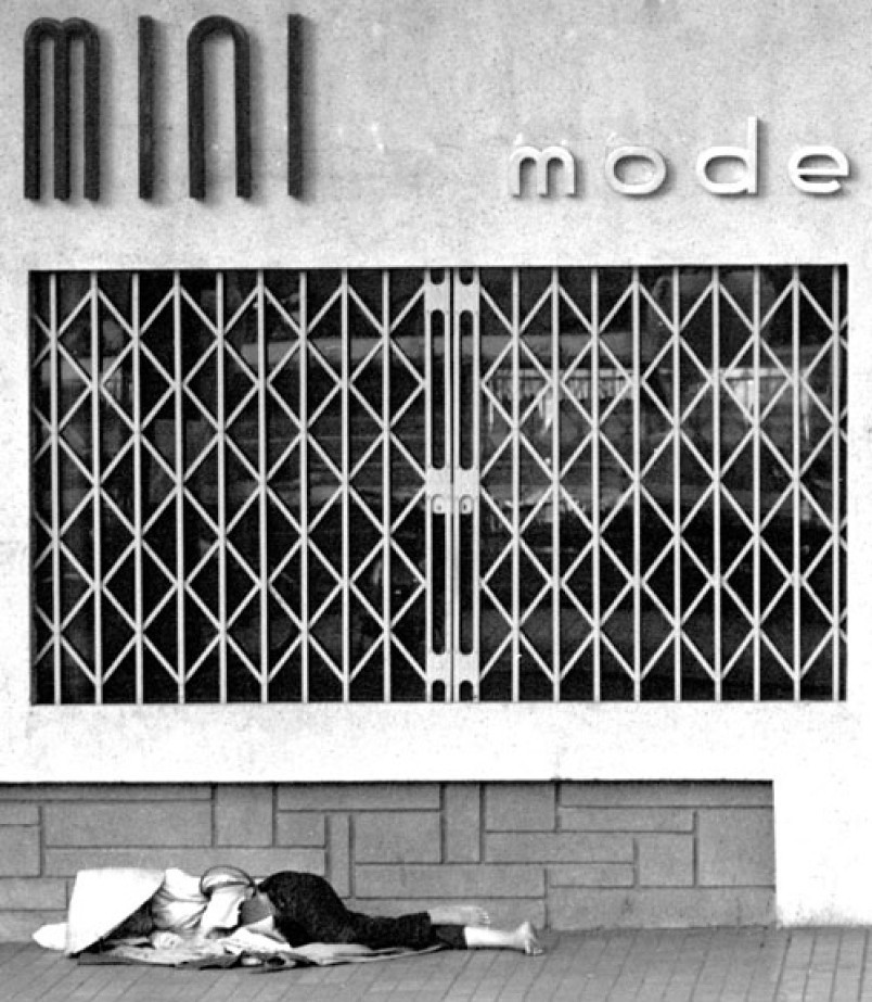 Một người phụ nữ có giấc ngủ trưa trên vỉa hè, phía trước một cửa hàng ở Sài Gòn.