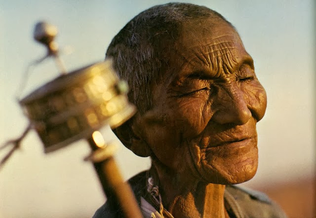 Một tín đồ Phật giáo cao tuổi cầm trên tay bánh xe cầu nguyện.