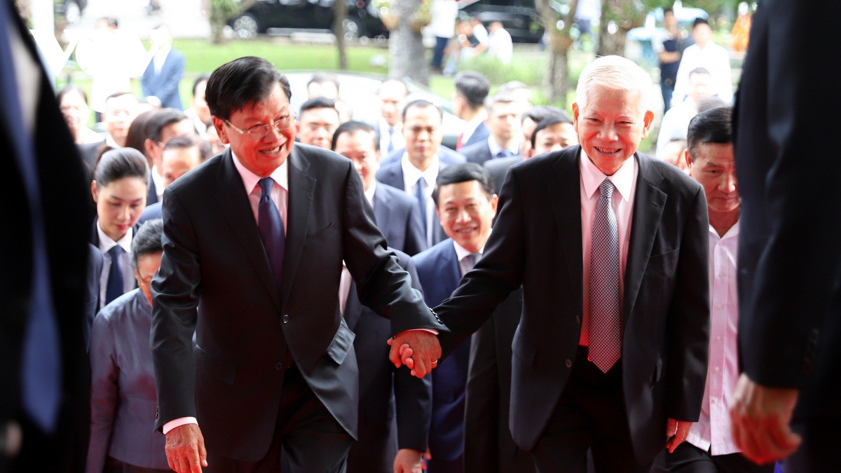 Sau đó, đoàn di chuyến đến Nhà khách T78 và dự Lễ phát động đợt vận động và tiếp nhận các nguồn đóng góp tự nguyện hỗ trợ đồng bào các tỉnh miền Bắc bị thiệt hại cho bão số 3. Ảnh: Tổng Bí thư, Chủ tịch nước Lào nắm tay nguyên Chủ tịch nước Nguyễn Minh Triết đi vào hội trường (ảnh Hà Khánh)