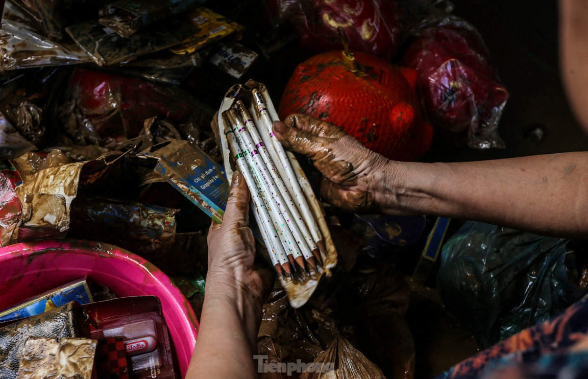 “Bao năm sống ở đây, chưa bao giờ có đợt lũ lên nhanh, gây ngập sâu như vậy. Vợ chồng tôi chỉ kịp chạy lên tầng trên tránh nạn, tất cả tài sản, đồ đạc bị ngâm trong nước. Giờ thì trắng tay...”, bà Tâm nói. Trong hình, vợ chồng bà Tâm cố nhặt nhạnh những gì còn sót lại sau trận lũ dữ.