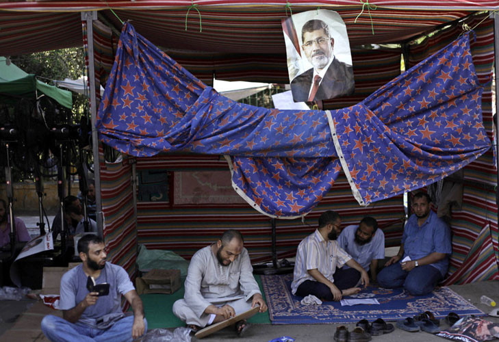 Người biểu tình ủng hộ Tổng thống vừa bị lật đổ Mohamed Mursi ngồi nghỉ trong lán trại.
