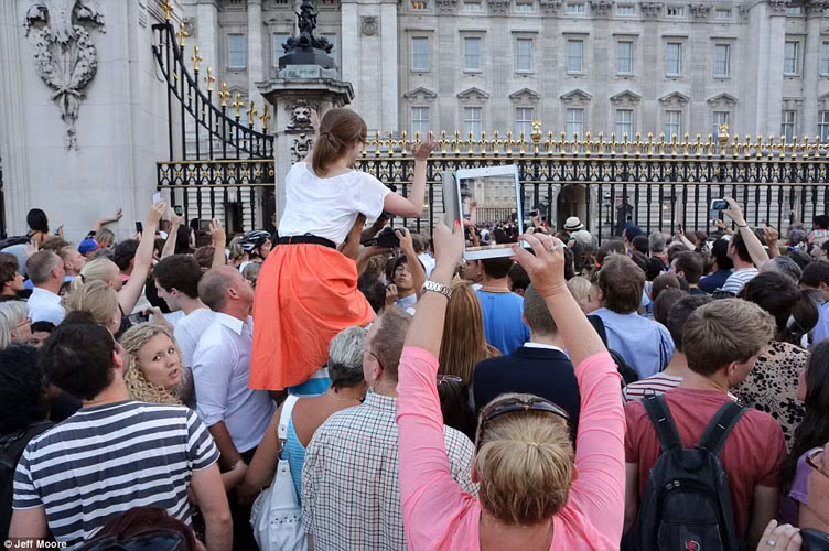 Thông cáo báo chí của Hoàng gia Anh cho biết, Công tước xứ Cambirdge, Hoàng tử William đã có mặt khi vợ lâm bồn. Công tước sẽ có 2 tuần để bên vợ và con trai trước khi phải đi làm nhiệm vụ. Trong ảnh, dân Anh "bủa vây" cung điện Buckingham sau khi tin vui của Hoàng gia được thông báo và lan truyền.
