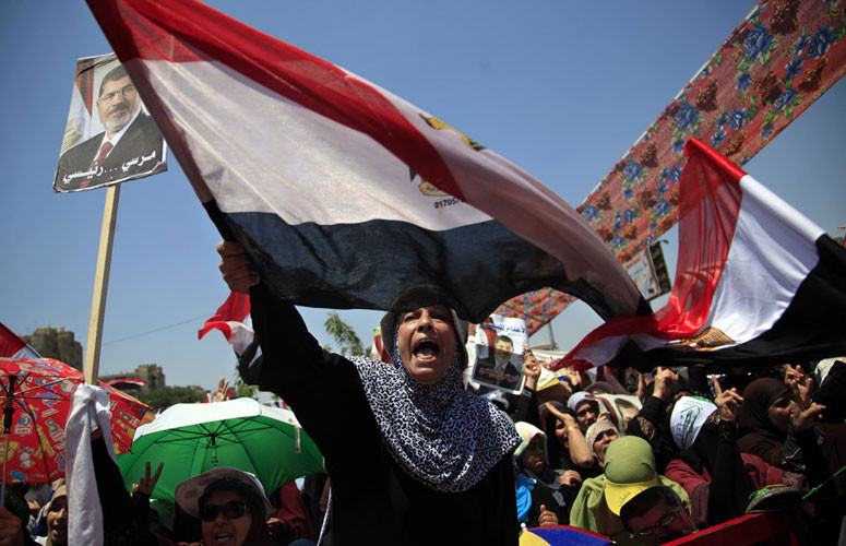 Người biểu tình với chân dung cựu Tổng thống Mursi và băng rôn, khẩu ngữ hô vang khẩu hiệu chống quân đội.