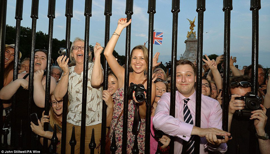 Hoàng tử chào đời lúc 16h24 (giờ địa phương) hôm qua, nặng 3,8 kg. Sức khỏe của Công nương lẫn Hoàng tử đều tốt và cả hai ở lại bệnh viện St Mary's, London qua đêm. Trong ảnh, dân Anh chen nhau bám vào hàng rào của cung điện Buckingham, chúc mừng Hoàng gia có tin vui.