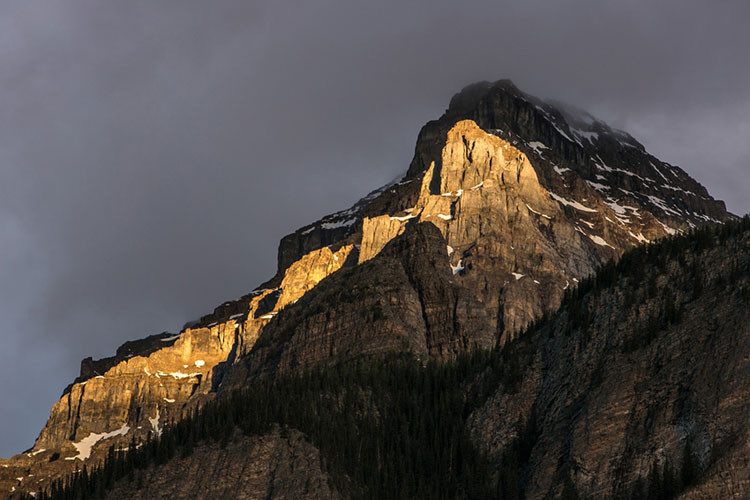 Nắng nhuộn vàng một phần dãy núi đá sừng sững.