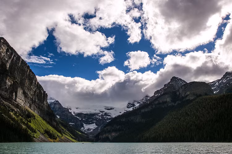 Ngọn núi phủ tuyết trắng đẹp ngoạn mục phản chiếu qua mặt hồ Louise trong vắt và phẳng lặng.